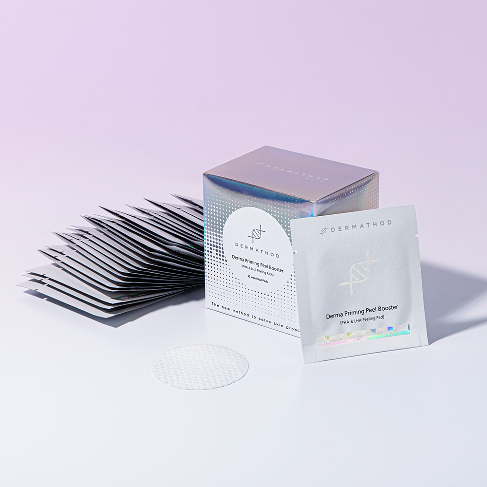 roduktfoto des Dermathod Derma Priming Peel Booster: eine silberne Box, Einmalverpackungen und ein einzelnes Peeling Pad mit geprägter Struktur.“ • „Dermathod Derma Priming Peel Booster Pads – Nahaufnahme der geprägten Seite für sanftes, aber effektives Peeling.“ • „Einzeln verpackte Pads des Dermathod Derma Priming Peel Booster, präsentiert in einem aufgeräumten Layout. Dermathod definiert das Peeling mit seinen Peeling Booster Pads neu
