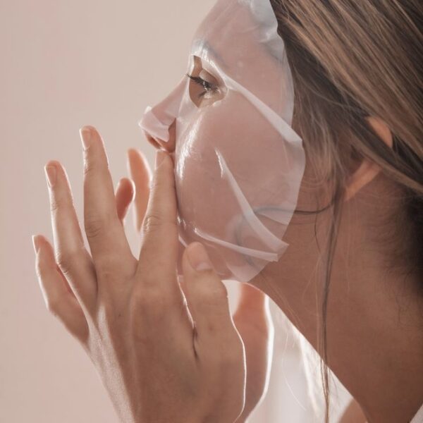 Frau legt eine Exosome Sheet Mask auf ihr Gesicht – für intensive Hautpflege.