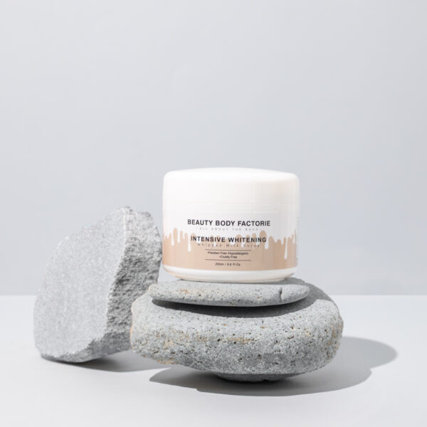 Intensiv aufhellendes Milch-Körperpeeling von Beauty Body Factorie auf grauen Steinen